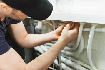Man installing pipe system of bathtub with hydromassage.