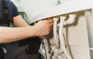 Man installing pipe system of bathtub with hydromassage.