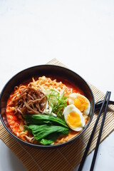 a bowl of spicy noodle with various topping or known as  ramen 