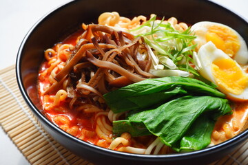 a bowl of spicy noodle with various topping or known as  ramen 