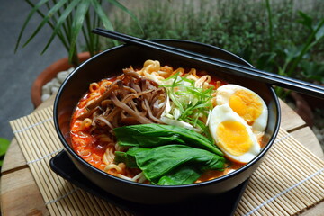a bowl of spicy noodle with various topping or known as  ramen 