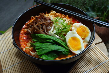 a bowl of spicy noodle with various topping or known as  ramen 
