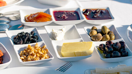 Turkish traditional breakfast served items: nuts, olives,berry jams, butter