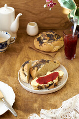Buns with butter and raspberry jam. Side view. Wooden background.