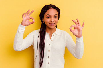 Young african american woman isolated on yellow background cheerful and confident showing ok...