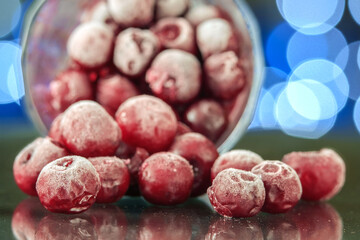 Closeup of the frozen cherry in the glass reflecting on the surface. blurred background selective focus