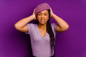 Young african american woman isolated on yellow background Young african american woman isolated on yellow background covering ears with hands trying not to hear too loud sound.