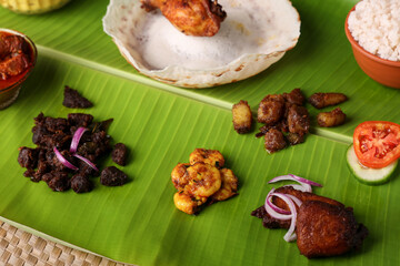 Appam with mutton stew Non-vegetarian sadhya Indian food for Onam sadya Christmas Easter celebration Kerala India Sri Lanka hoppers beef fry fish curry rice on banana leaf