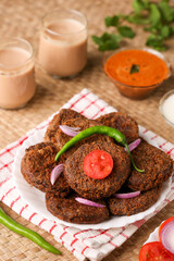 Many beef or chicken cutlet, tomato sauce Kerala South India. hot and spicy tea time snack on white plate, dark black background. fried meat of veal, mutton or fish. Top view Indian snack non veg food
