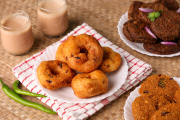 Medu Vada with tiffin sambar coconut chutney in traditional background , savory fried tea time snack of Kerala, Tamil Nadu South India. Top view of Indian veg breakfast food.