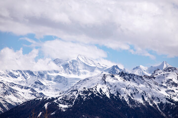Fototapeta na wymiar Winter landscape snowy mountains, sky and clouds. Mountain peaks in Swiss alps, Wallis.