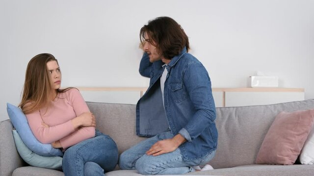 Domestic abusement. Angry husband shouting and screaming at his wife, young frightened woman feeling scared