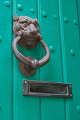 Green door with lion door knocker