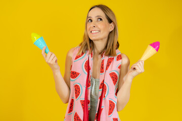 Happy woman wearing swimsuit and beach towel holding two ice creams