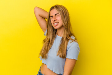 Young blonde caucasian woman isolated on yellow background suffering neck pain due to sedentary lifestyle.