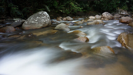 Beautiful clear river stream in lush green forest in Kuala Kubu Bharu, Selangor, Malaysia.