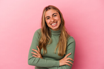 Young blonde caucasian woman isolated on pink background laughing and having fun.