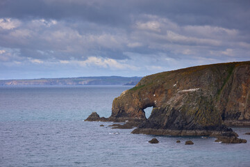 cave in huge rocky cliffs of the Kilfarrasy Beach. Co.Waterford Coastline, Ireland