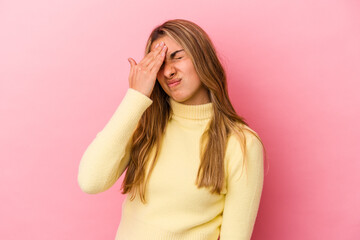 Fototapeta premium Young blonde caucasian woman isolated on pink background having a head ache, touching front of the face.