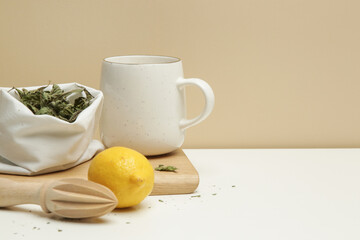 Natural mint tea in reusable bulk sack and ceramic mug. Zero waste and sustainable lifestyle. Groceries in reusable textile bags on table.