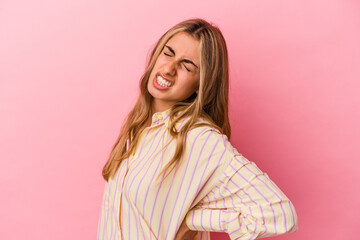 Young blonde caucasian woman isolated on pink background suffering a back pain.