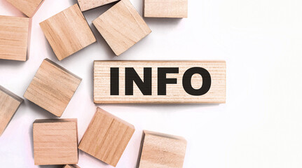 On a light background, wooden cubes and a wooden block with the text INFO. View from above