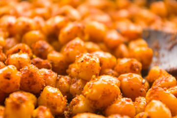 Cooking chickpeas with spices in a pan, close-up