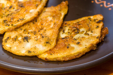 Vegetarian food - celery tuber slices fried in batter in a ceramic plate on a wooden table, close up