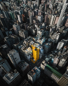Hong Kong - 14 February 2019: Aerial view of urban grid on Kowloon and yellow tower at sunset, Hong Kong
