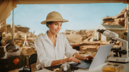 Archaeological Digging Site: Famous Female Archaeologist Doing Research, Using Laptop, Analysing...