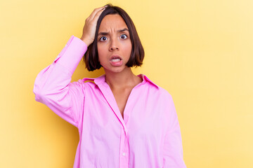 Young mixed race woman isolated on yellow background being shocked, she has remembered important meeting.