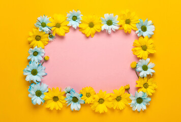 Spring flowers frame. Floral wreath on yellow background. Springtime. Flat lay, top view.