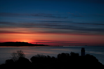 sunrise over a silhouette of Ha lighthouse in Aberdour, fife,  scotland.