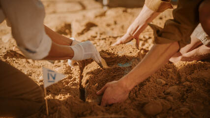 Archaeological Digging Site: Two Great Archeologists Work on Excavation Site, Carefully Cleaning, Lifting Newly Discovered Ancient Civilization Cultural Artifact, Historic Clay Tablet. Focus on Hands