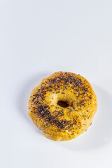 Freshly made and baked bagel on white background. Homemade cooking and pastry concept. Vertical photo and selective focus