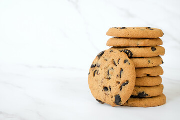 Stack of homemade chocolate chip cookies on marble background with copy space. Recipe of cookies with chocolate chips. Snack or treat in cafe or restaurant menu.