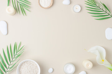 Spa background with skin care products, stones, candles and palm leaves on pastel beige. Flat lay,copy space