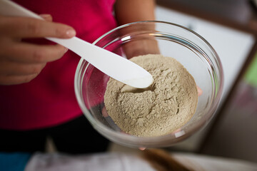 The process of preparing a mask for skin and face from spirulina and seaweed in a cup. Spa salon and beauty treatments. Skin care. Powder