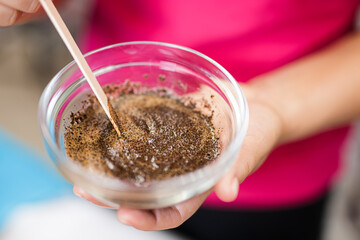 The process of making a coffee body scrub by a beautician. Mixing the ingredients by a doctor before applying to the skin. Skin protection and care.