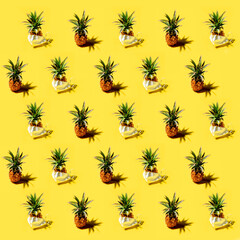 Fototapeta premium Many pineapples on a solid yellow background pattern