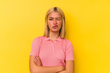 Young venezuelan woman isolated on yellow background unhappy looking in camera with sarcastic expression.