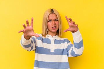 Young venezuelan woman isolated on yellow background upset screaming with tense hands.