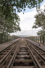 Fototapeta premium Railway track on a bridge, view of a cloudy sky, distancing perspective
