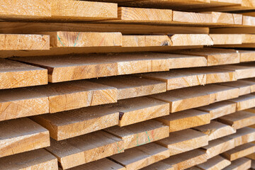 Stack of new wooden studs at the lumber yard. Industrial timber building materials.