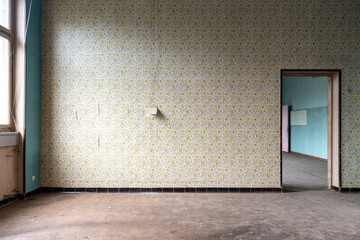 Abandoned empty room with flowery wallpaper