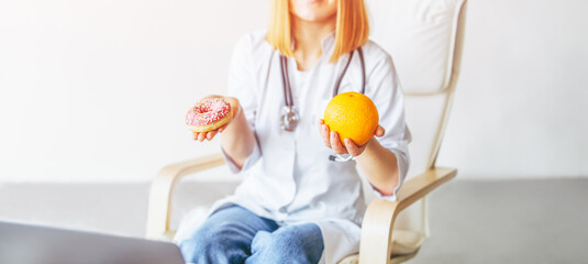 Obraz na płótnie Canvas Nutritionist female doctor holding orange and donut in hands, diet concept.