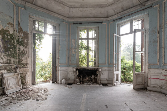 Abandoned castle, room with fireplace and large broken windows