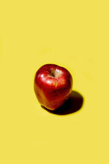 Red apple on a solid yellow background