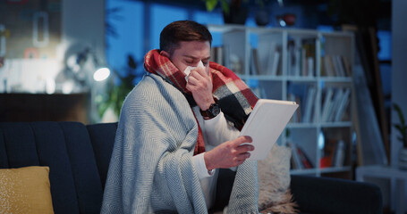 Fototapeta premium Miserable unwell sick caucasian man videocalling private doctor family therapist asking about medication suffering illness at home. Videochatting. Tablet. Healthcare.
