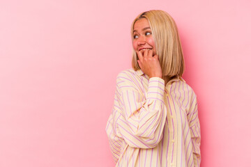 Young venezuelan woman isolated on pink background relaxed thinking about something looking at a copy space.